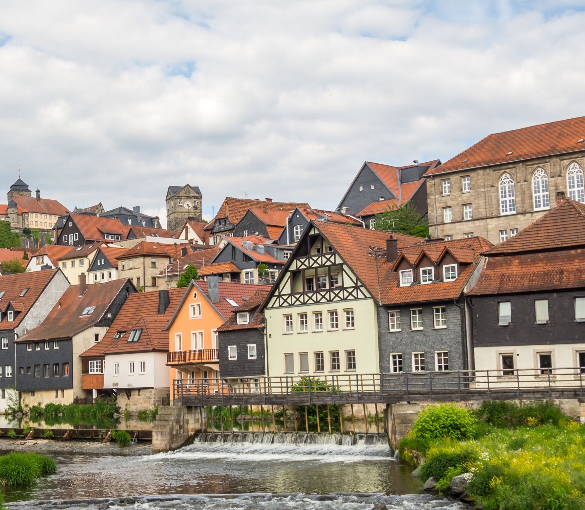 Stadtbild mit Immobilien und im Vordergrund ein Fluss